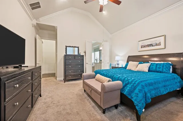 a bedroom with a large bed and a flat screen tv