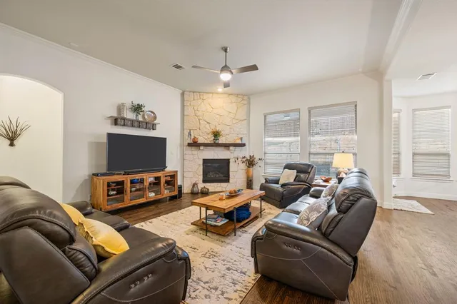 a living room with furniture a flat screen tv and a fireplace