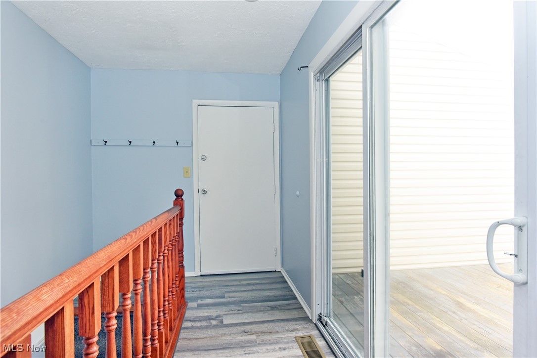 2276 Raber Road, Unit F Uniontown, OH 44685 - Photo 23 of 30 Hallway with light wood-style floors, an upstairs landing, and a textured ceiling