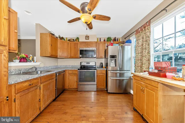 a kitchen with stainless steel appliances granite countertop a sink and refrigerator