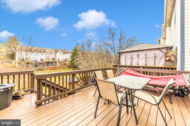 a view of a roof deck with table and chairs with wooden floor and fence