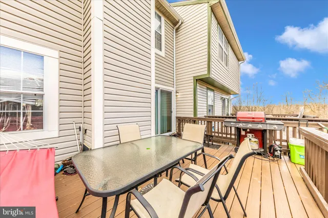 a view of a patio with table and chairs with wooden floor and fence