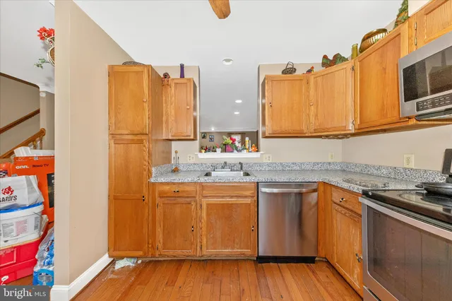 a kitchen with stainless steel appliances a stove a sink and a refrigerator