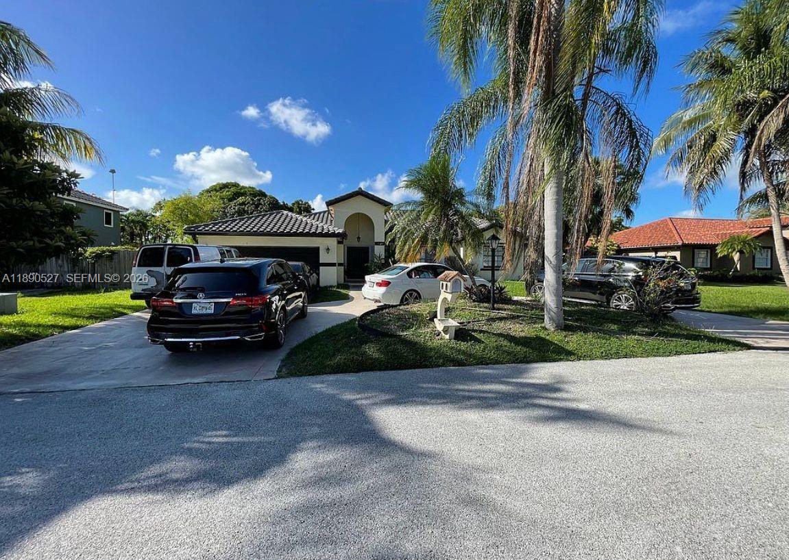 15181 Southwest 156th Terrace Miami, FL 33187 - Photo 15 of 32 a front view of a house with a garden and car parked