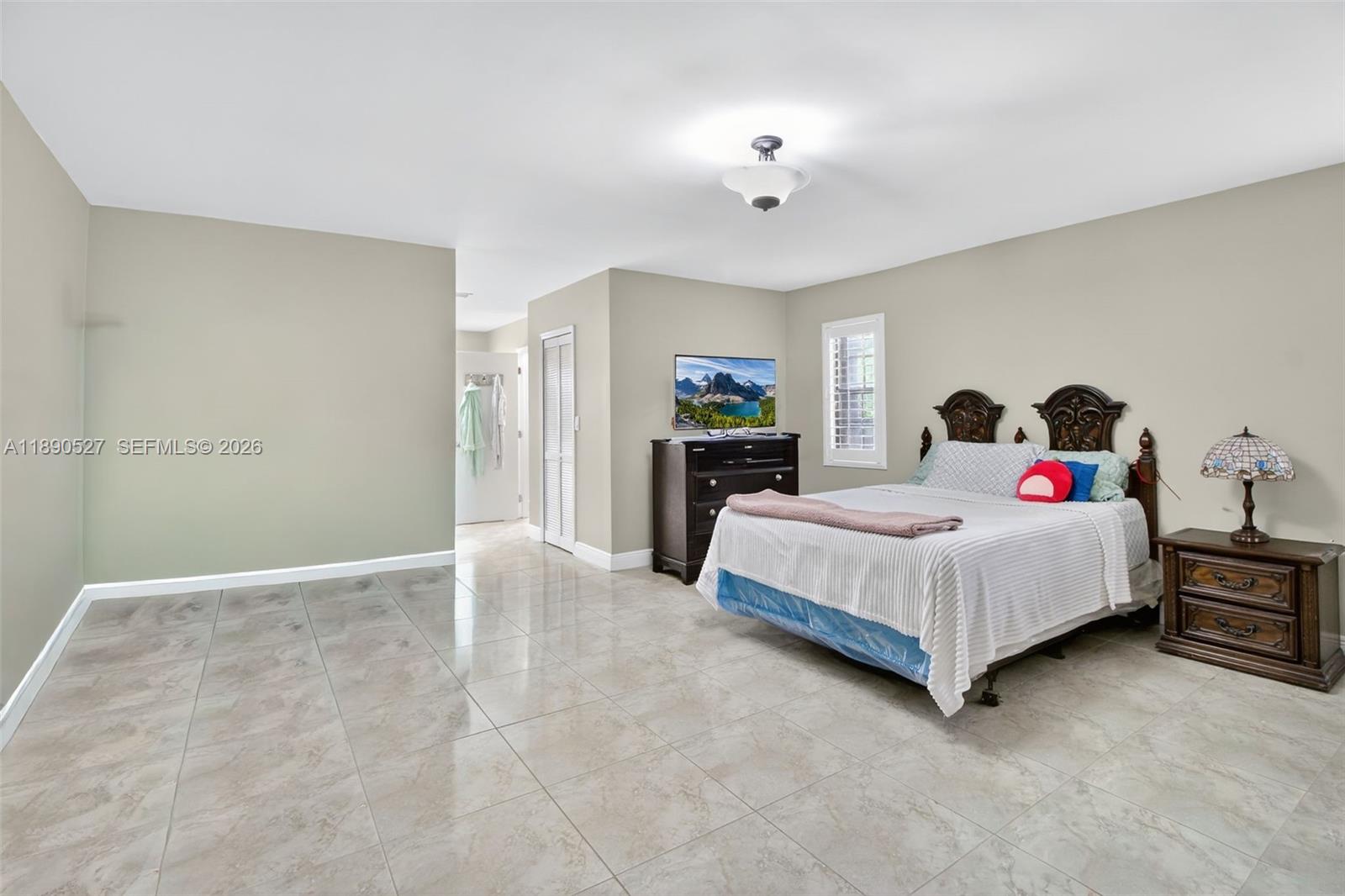 15181 Southwest 156th Terrace Miami, FL 33187 - Photo 22 of 32 a spacious bedroom with a bed and a cabinets