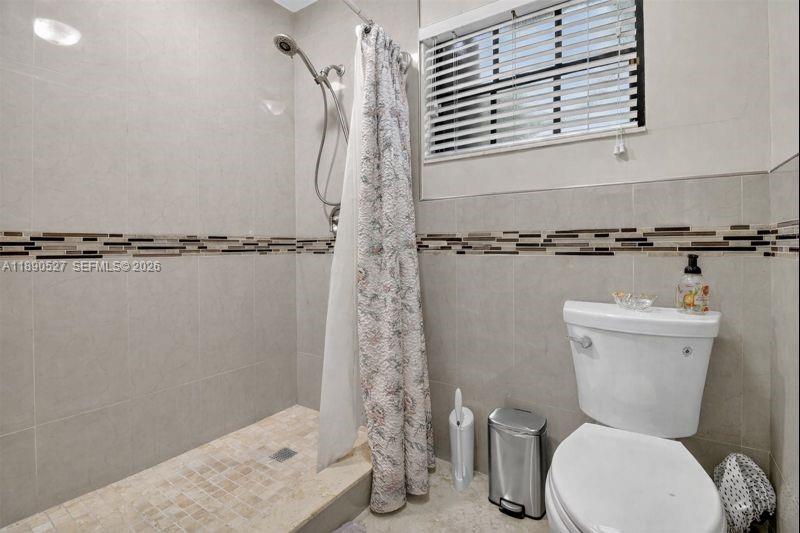 15181 Southwest 156th Terrace Miami, FL 33187 - Photo 28 of 43 a bathroom with a toilet and a shower