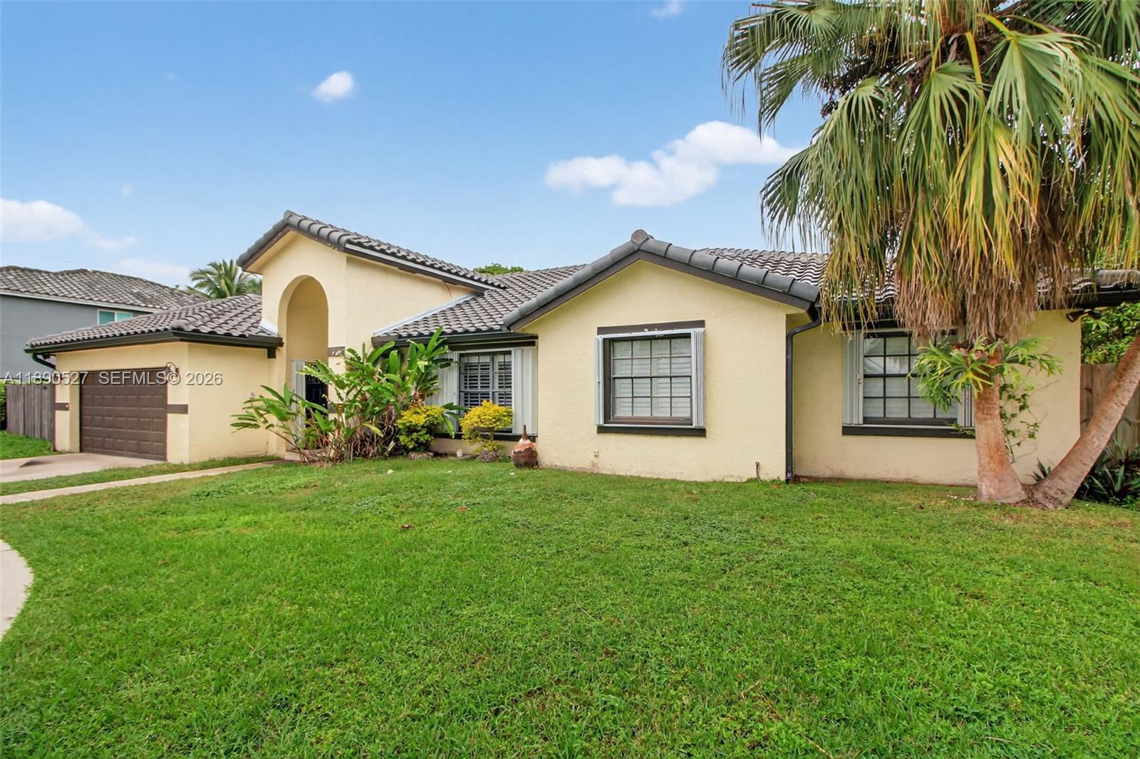 15181 Southwest 156th Terrace Miami, FL 33187 - Photo 3 of 32 a view of a house with a yard and palm trees