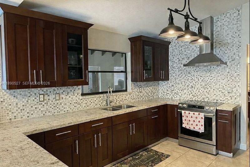 15181 Southwest 156th Terrace Miami, FL 33187 - Photo 9 of 32 a kitchen with stainless steel appliances granite countertop a sink stove and cabinets