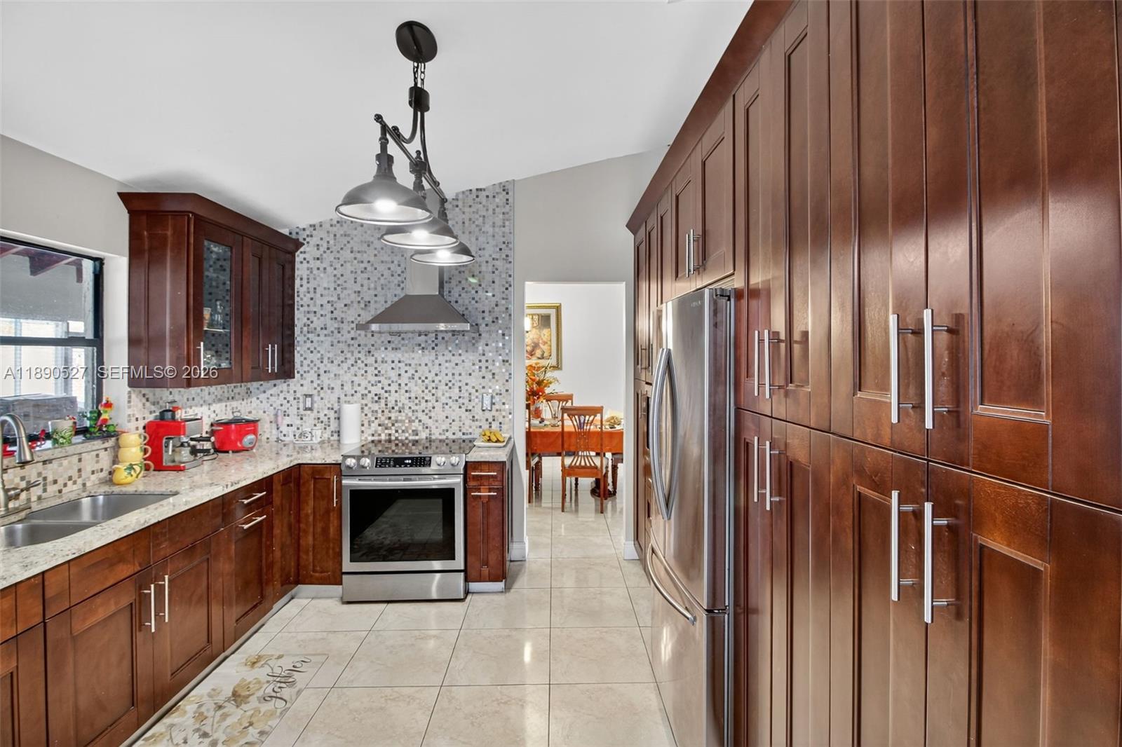 15181 Southwest 156th Terrace Miami, FL 33187 - Photo 10 of 32 a kitchen with stainless steel appliances granite countertop a refrigerator and a stove top oven