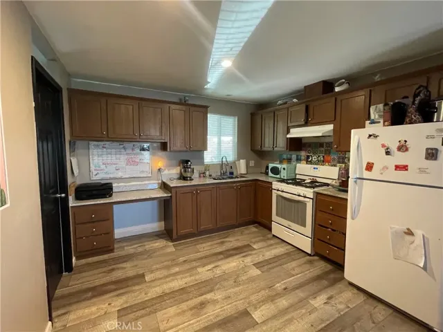 a kitchen with a refrigerator sink and cabinets