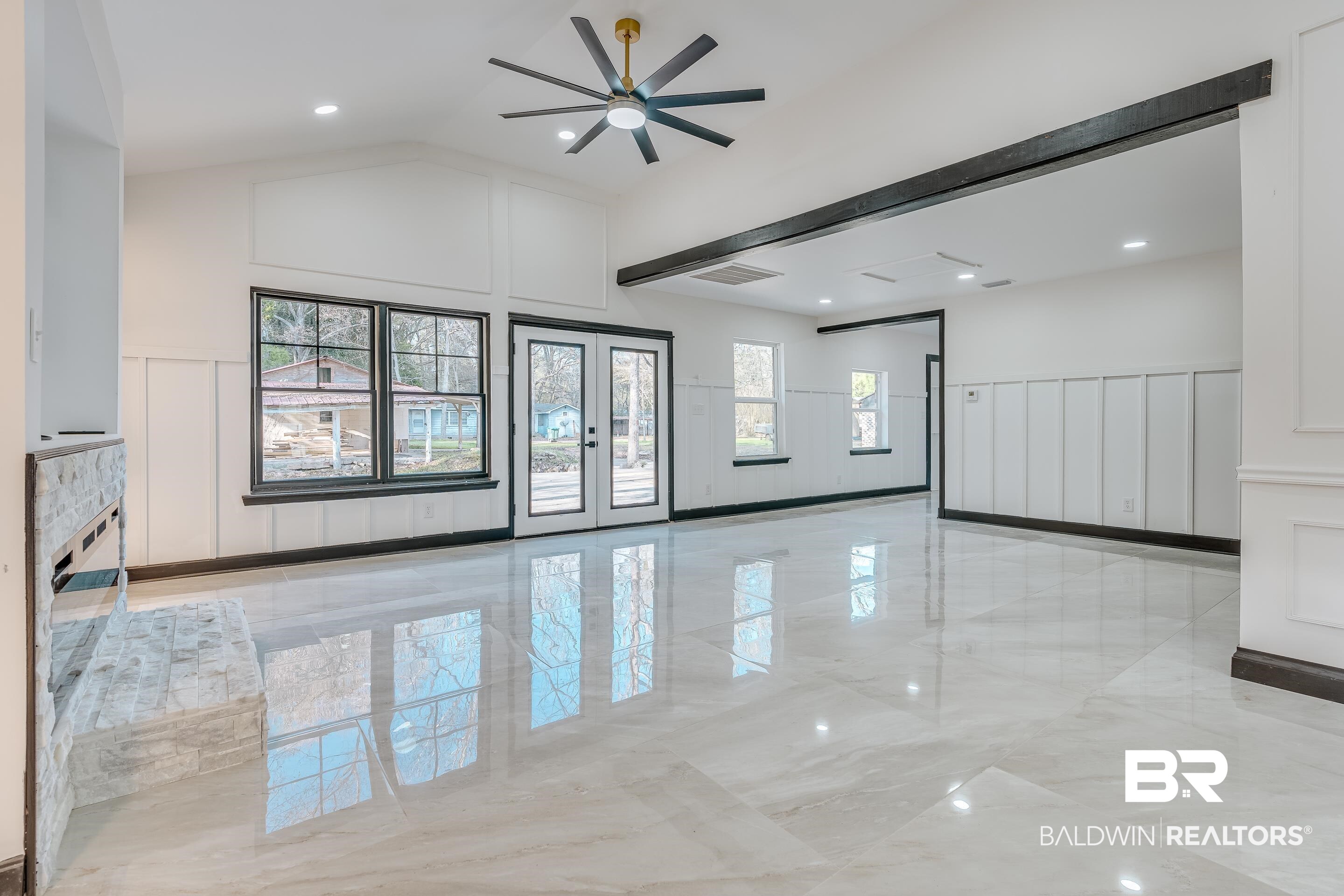 1190 Military Road Mount Vernon, AL 36560 - Photo 15 of 47 Empty room featuring a decorative wall, wainscoting, french doors, high vaulted ceiling, and light marble finish flooring