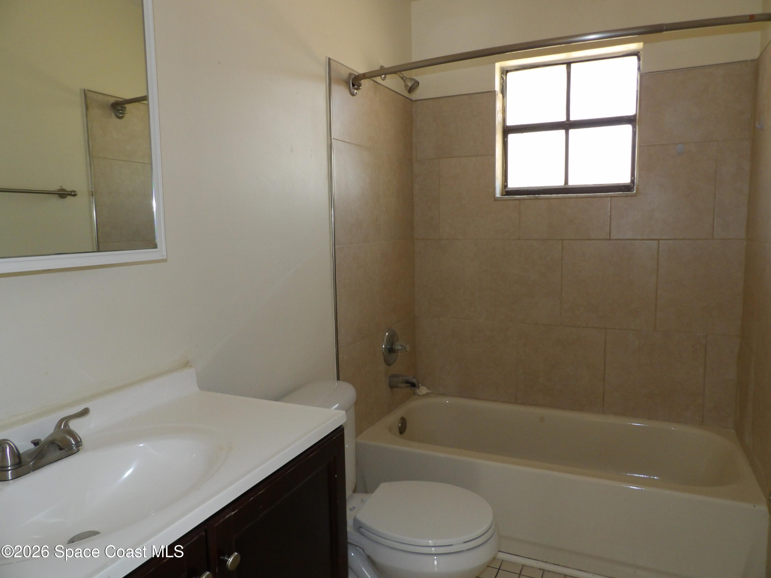 1899 Agora Circle Southeast, Unit 1 Palm Bay, FL 32909 - Photo 8 of 11 a bathroom with a sink toilet and shower