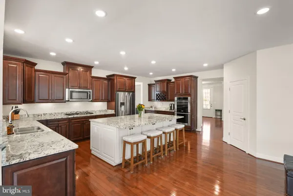 a spacious bedroom with a bed and a view of kitchen
