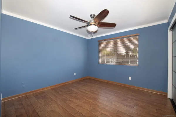 a view of an empty room with a ceiling fan and a window