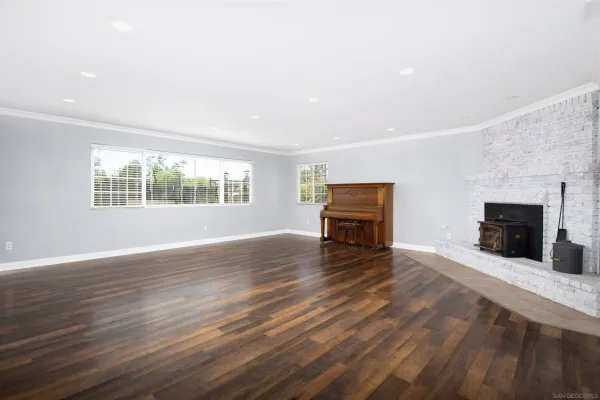 wooden floor fireplace and windows in an empty room