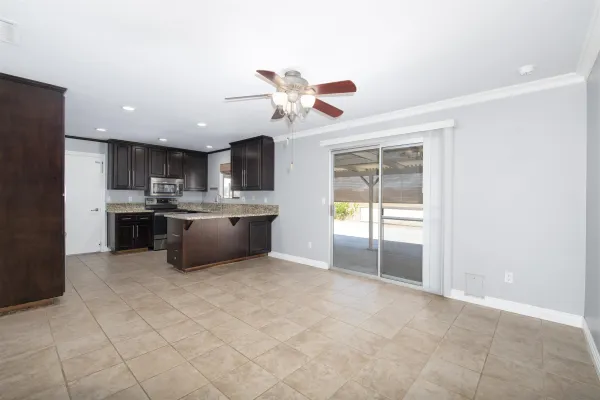 a kitchen with stainless steel appliances a sink a stove a refrigerator cabinets and a window