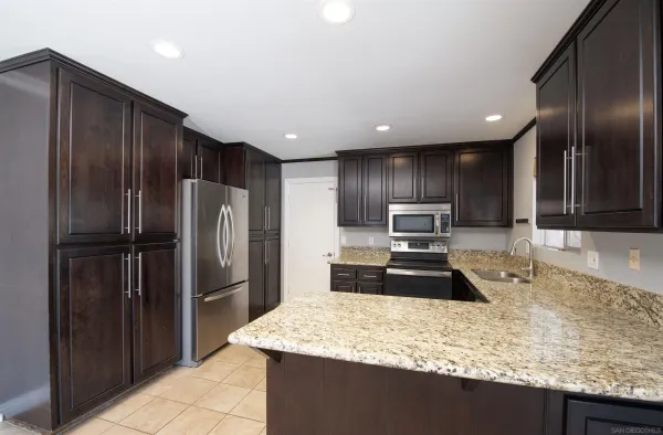 a kitchen with granite countertop stainless steel appliances and wooden cabinets