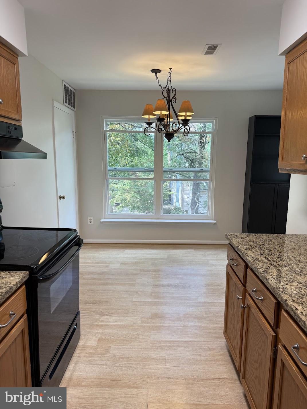 18290 Rolling Meadow Way, Unit 4 Olney, MD 20832 - Photo 8 of 18 a kitchen with a stove and a wooden floor