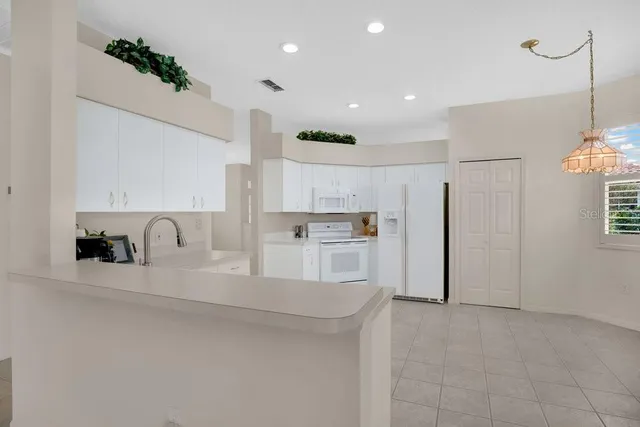 a large kitchen with cabinets and a refrigerator