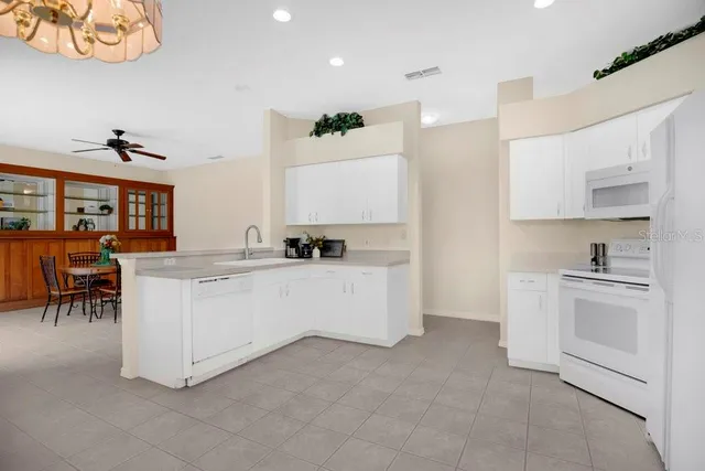 a large white kitchen with cabinets