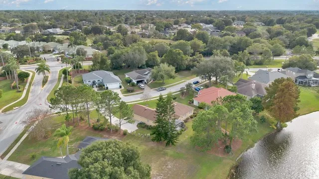 an aerial view of residential houses with outdoor space and trees