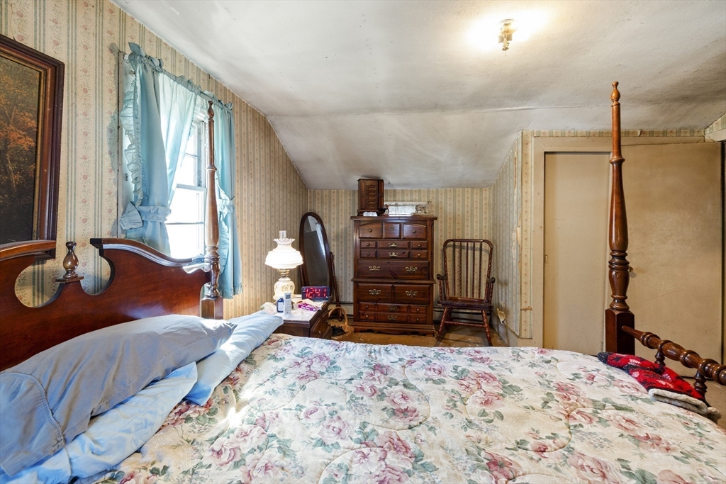 22-25 Macomber Road Monson, MA 01057 - Photo 25 of 34 a bed room with a bed dresser and a large mirror