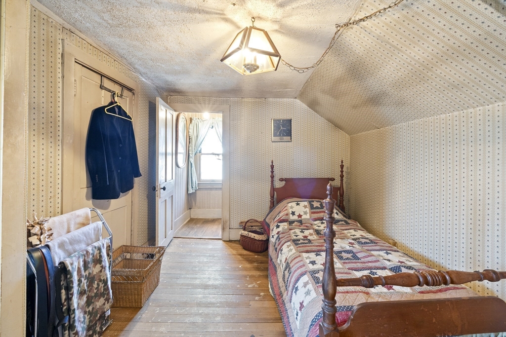 22-25 Macomber Road Monson, MA 01057 - Photo 29 of 34 a bedroom with a bed and a chandelier