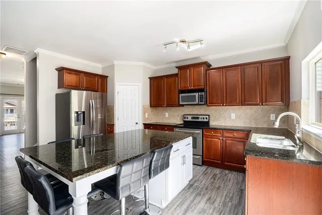 a kitchen with stainless steel appliances granite countertop a stove refrigerator sink and cabinets