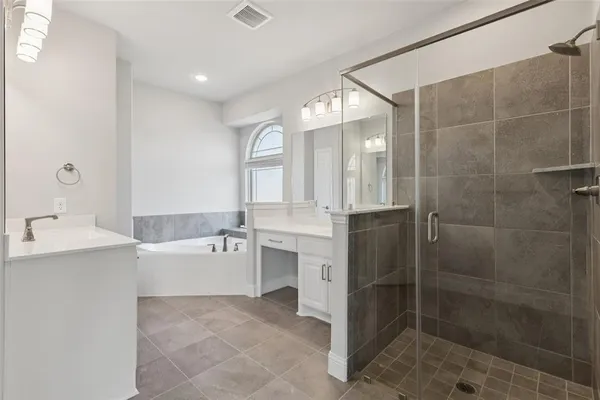 a bathroom with a bathtub shower sink and mirror