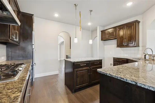 a kitchen with granite countertop stainless steel appliances and wooden cabinets