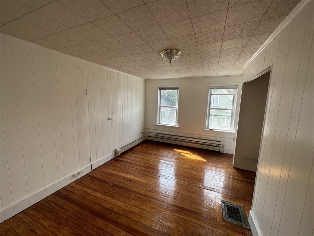 74 Pearson Avenue, Unit 2 Somerville, MA 02144 - Photo 5 of 11 a view of empty room with wooden floor and fan