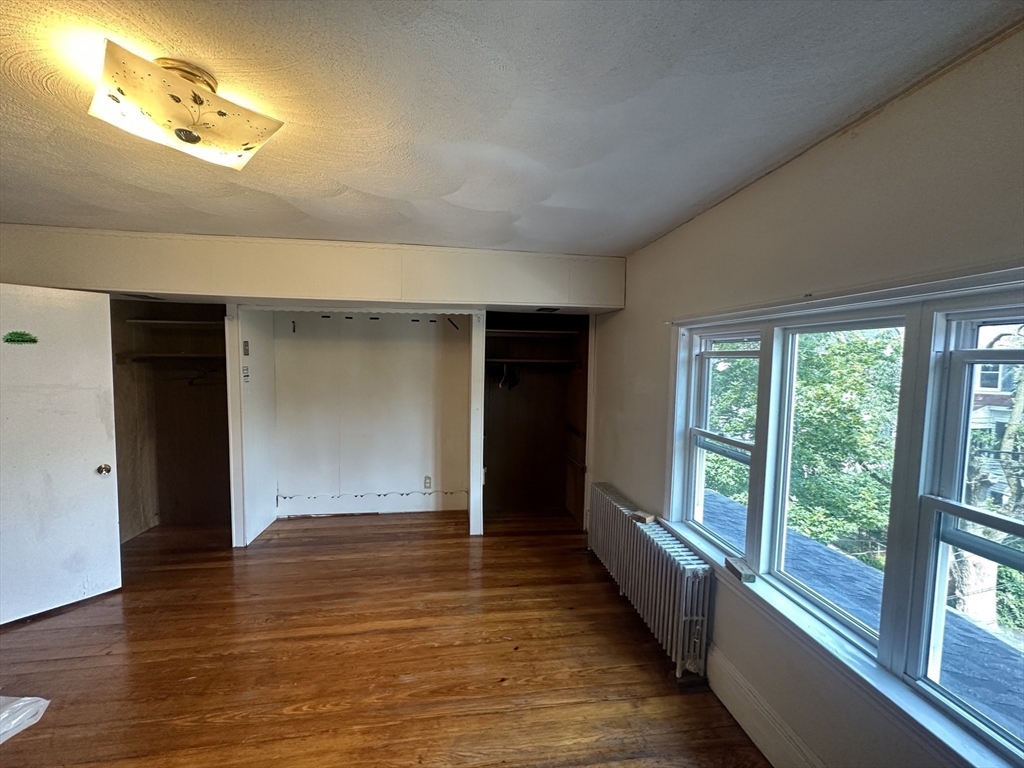 74 Pearson Avenue, Unit 2 Somerville, MA 02144 - Photo 6 of 11 wooden floor in an empty room with a window