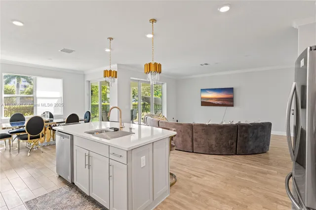 a very nice looking open dining room with kitchen island furniture a large window and kitchen view
