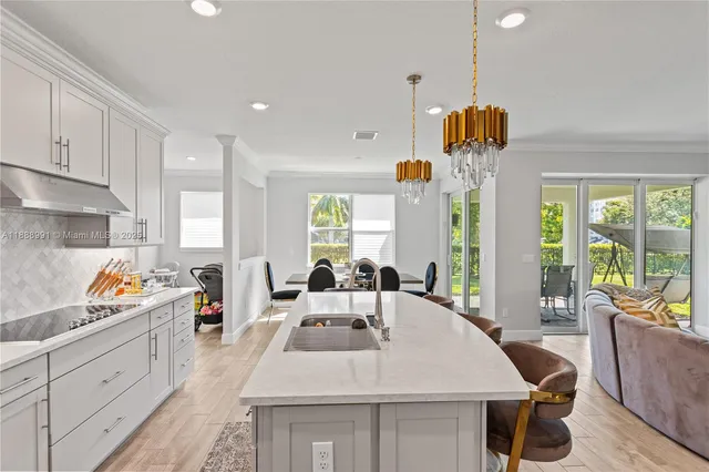 a kitchen that has a lot of white cabinets and stainless steel appliances