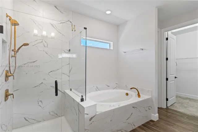 a spacious bathroom with a double vanity sink a mirror and a bathtub