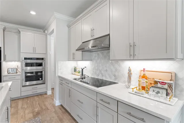 a living room with stainless steel appliances furniture a kitchen view and a fireplace