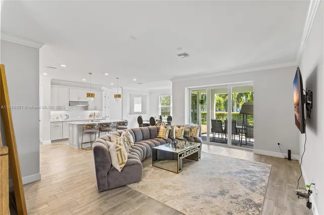 a living room with furniture large window and wooden floor