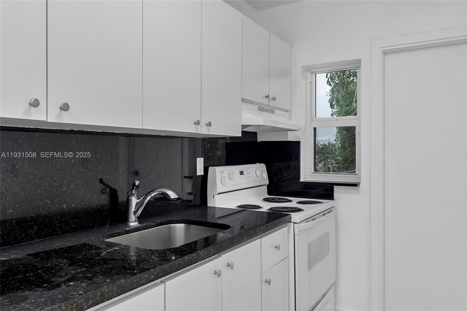 634 Southwest 10th Street, Unit 4 Miami, FL 33130 - Photo 12 of 19 a kitchen with granite countertop white cabinets and sink