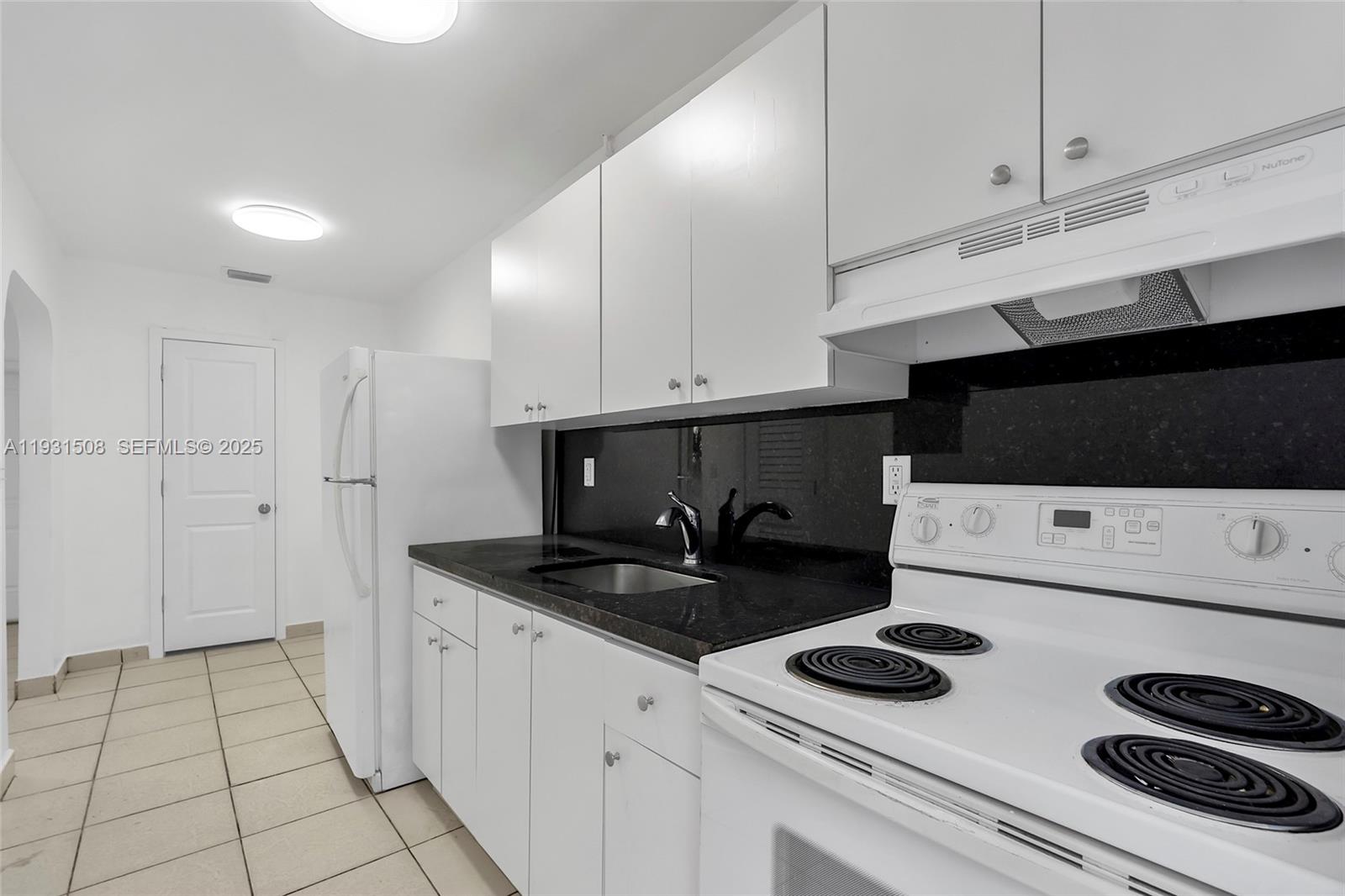 634 Southwest 10th Street, Unit 4 Miami, FL 33130 - Photo 13 of 19 a kitchen with white cabinets and appliances