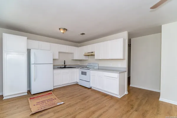 a kitchen with stainless steel appliances granite countertop a refrigerator and a stove top oven