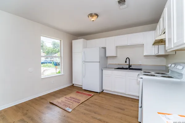 a kitchen with a sink cabinets stainless steel appliances and a window