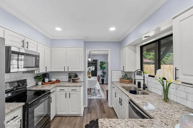 a kitchen that has a lot of cabinets in it wooden floor and a sink
