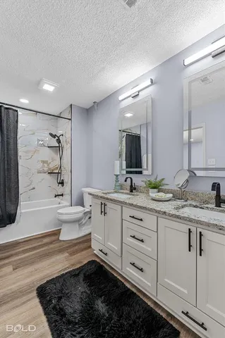 a bathroom with a double vanity sink a toilet and a bathtub