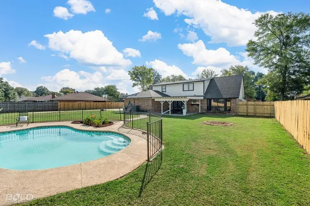 a view of a house with pool and a yard