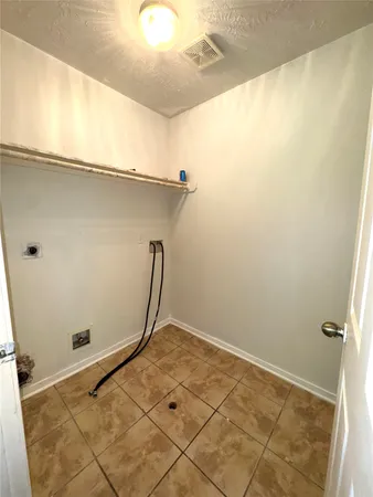 a view of a room with rack on the wall and a potted plant