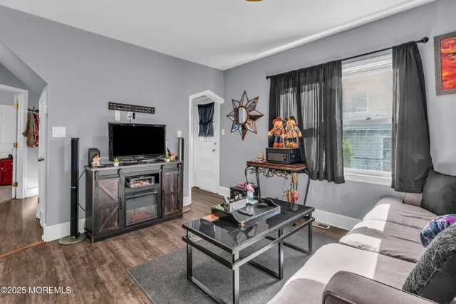 a living room with furniture a flat screen tv and a floor to ceiling window