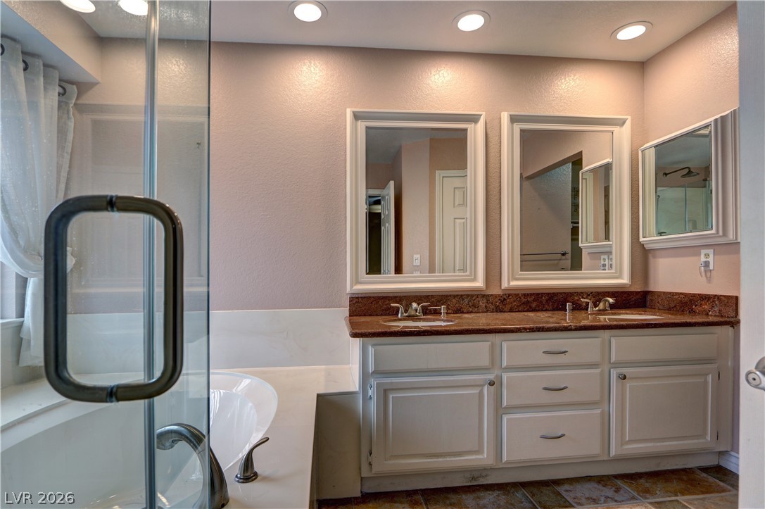 2108 Crestpoint Way Las Vegas, NV 89134 - Photo 16 of 27 Indulge in a primary bathroom featuring a spacious double vanity and a luxurious soaking tub.