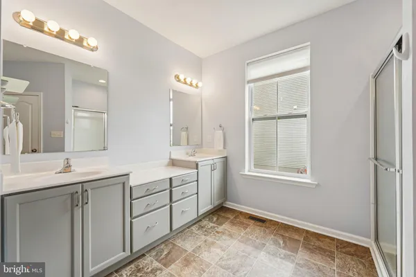 a bathroom with a sink double vanity and a mirror