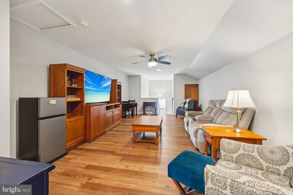 a living room with furniture a chandelier and kitchen view