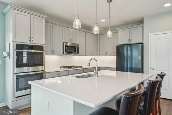 a kitchen with kitchen island a counter top space appliances and cabinets